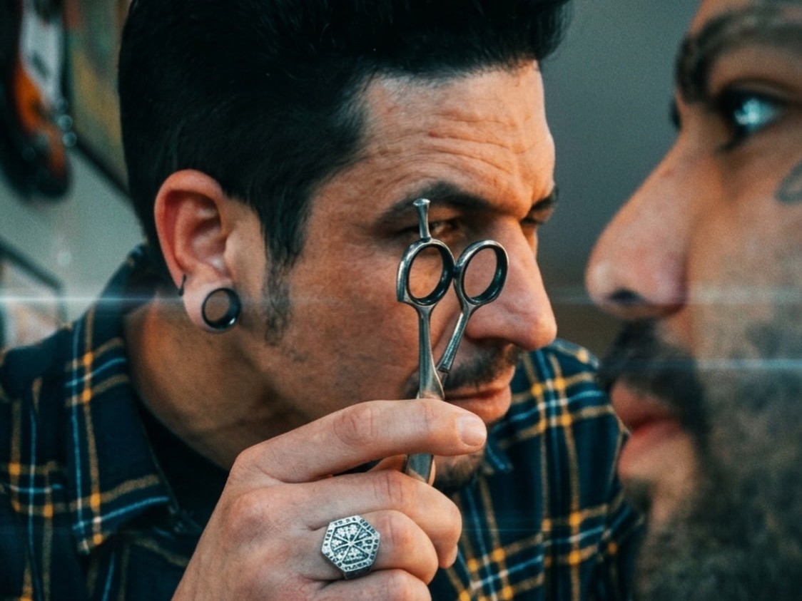 Barbeiro a trabalhar no corte de cabelo de cliente na Rock n Razor